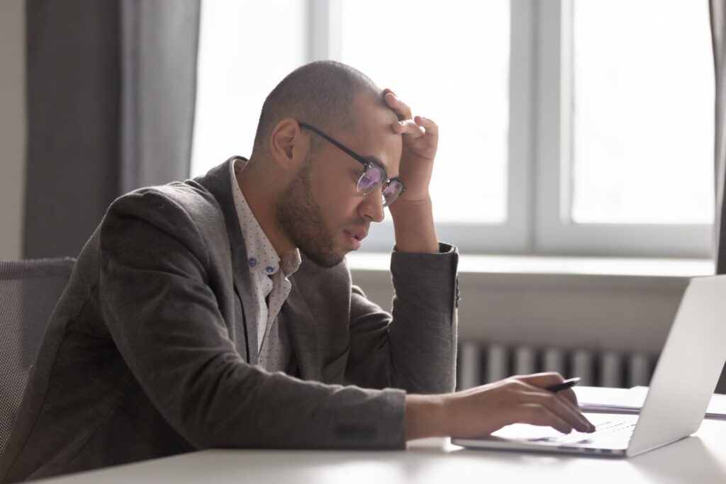 a person in a suit sitting at a desk with a laptop