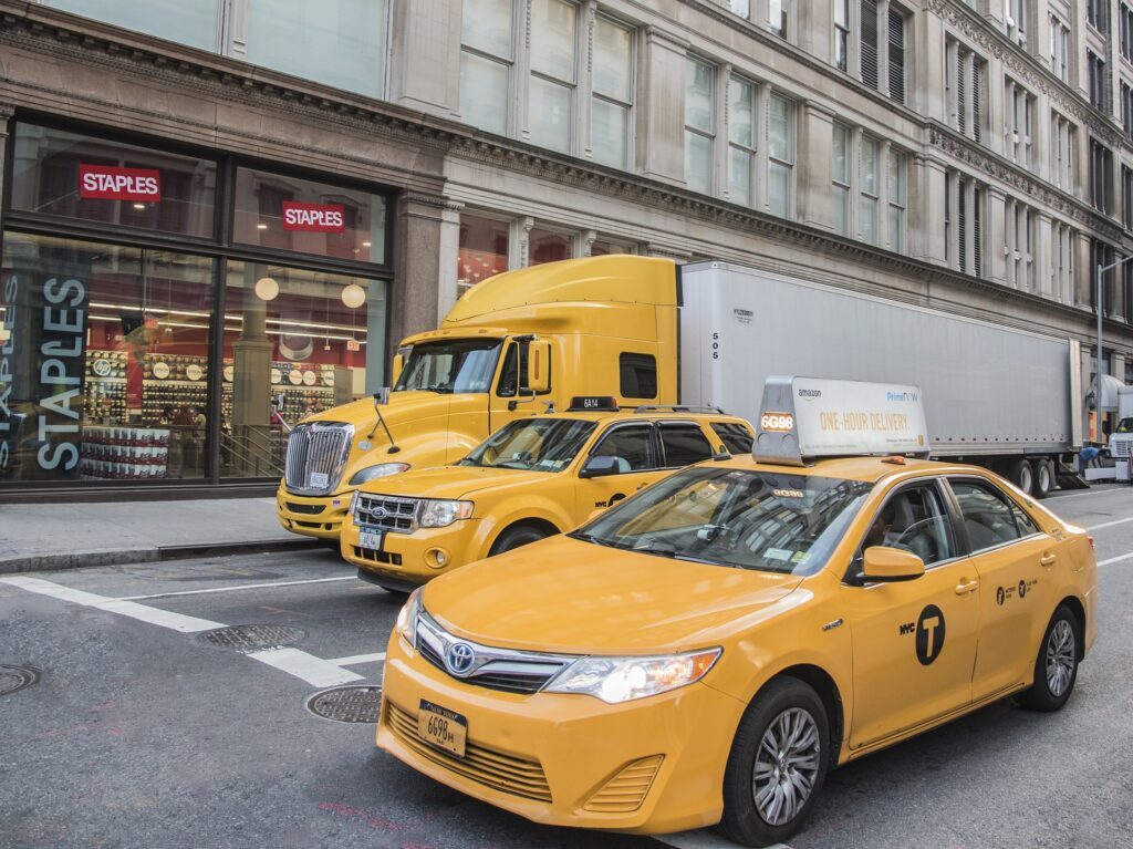 a group of yellow cars and truck on a street