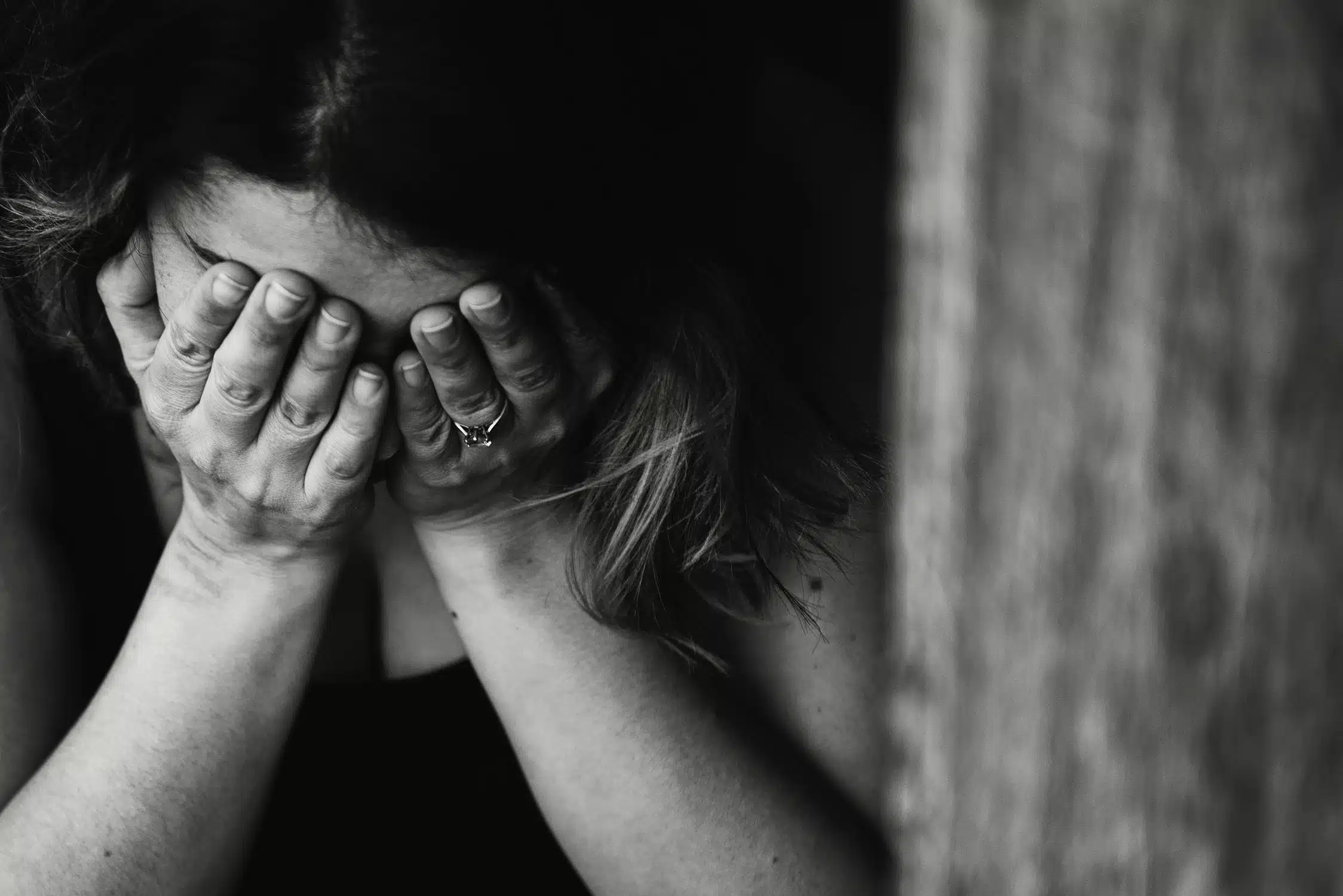 Woman covering her face with her hands in distress