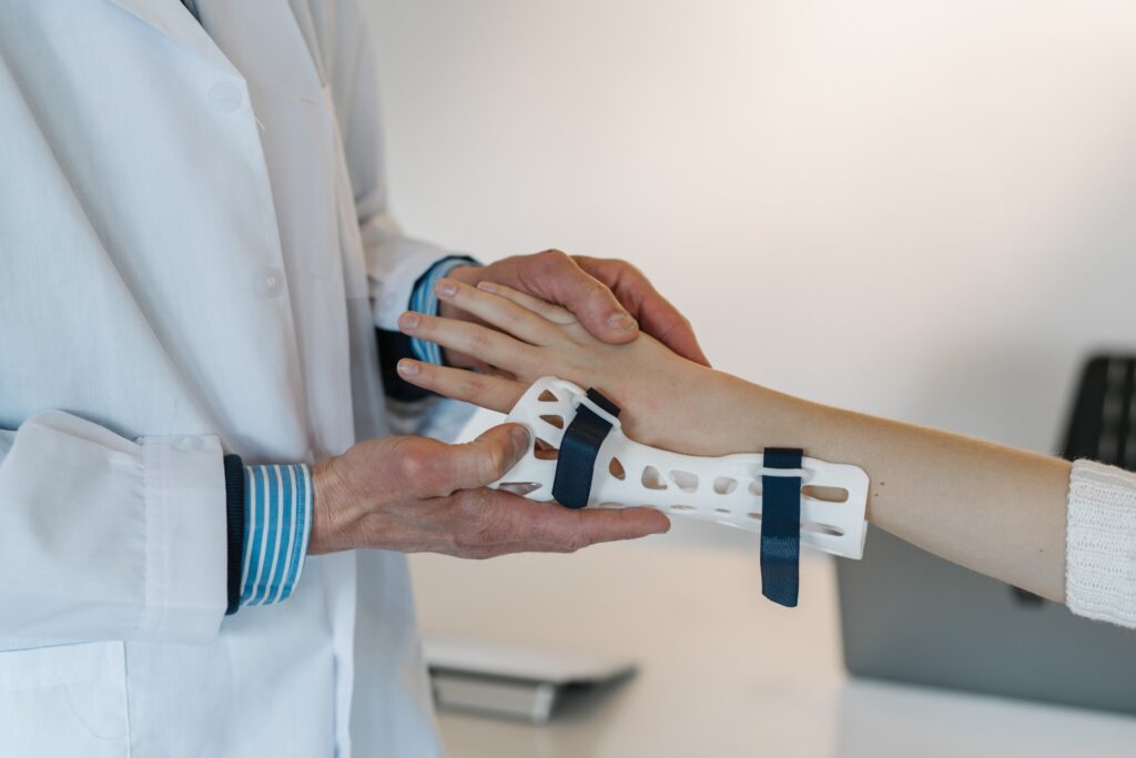 a person wearing a white coat holding a wrist brace