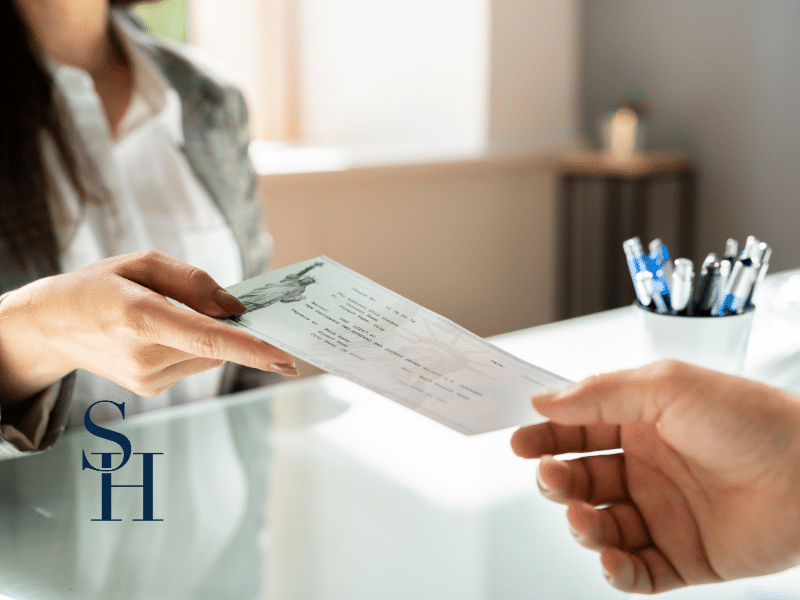 woman handing over workers compensation check