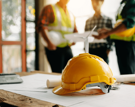 construction helmet on table in front of workers